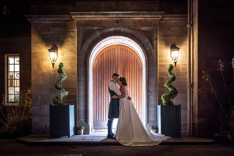 Bride and groom kiss outside main entrance